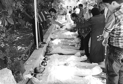 8月21日，在叙利亚首都大马士革的杜马镇，人们辨认遇难者遗体。新华社发