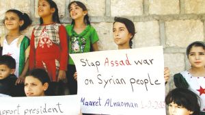 图为叙利亚儿童举着反战标语。