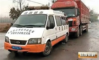 河南省永城市，一辆执法车挡在大货车前面。央视截图