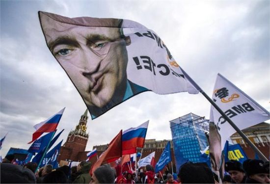 3月18日，俄罗斯民众挥舞着印有普京头像的旗帜，在红场欢庆克里米亚入俄。