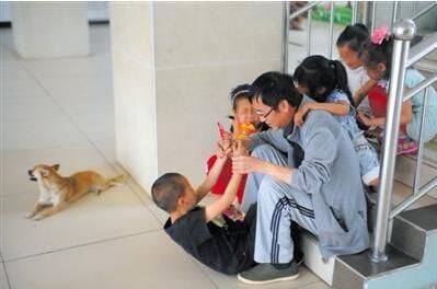 2016年5月，山西临汾红丝带学校校长郭小平在学校里与孩子们玩耍。图/视觉中国