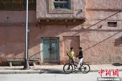 9月23日，两名维吾尔族少年在古城街边聊天。