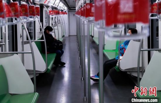 资料图：两位乘客戴着口罩在地铁上“隔位而坐”。　汤彦俊