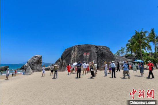 6月8日，海南三亚，游客在天涯海角游览区游玩。当日，恰逢世界海洋日，海南省三亚市天涯海角游览区迎来大批游客。蔚蓝海面游船穿梭，沙滩上游客尽情玩耍、拍摄留念，尽情感受海洋生态的独特魅力。中新社记者