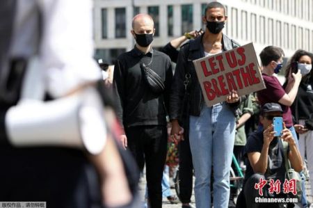 　　当地时间5月31日，德国柏林，一名男子手持标语站立在美国驻德国大使馆外，抗议美国警察暴力执法致非裔男子死亡事件。