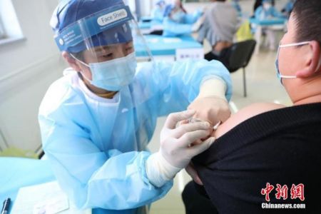 　　资料图：北京市海淀区学院路街道临时接种点内，医护人员为接种者注射疫苗。 中新社记者 蒋启明 摄